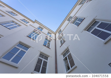 The smooth wall of the building with large windows seen from the very bottom. 104071558