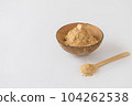 Bowl of maca root powder with spoon on white background 104262538