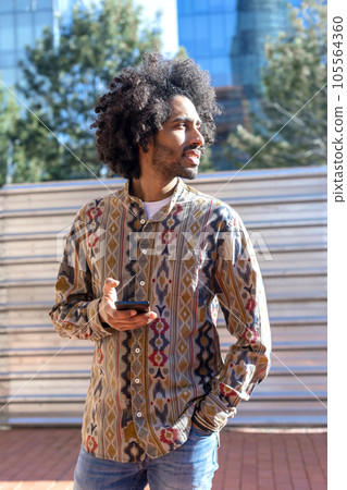 Portrait of handsome afro man using his mobile in the street. 105564360