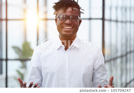 Portrait of handsome young smiling man in suit asking to make a choice between two products on his palms 105709247