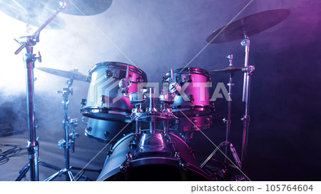 A drum set on a dark stage in the fog and neon lights. 105764604