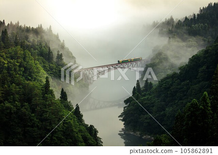 Tadami Line Kiha E120 series train crossing the first Tadami River bridge in the morning mist (Mishima Town, Fukushima Prefecture, late July) 105862891