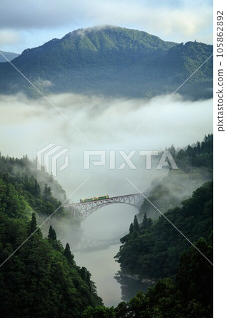 Tadami Line Kiha E120 series train crossing the first Tadami River bridge in the morning mist (Mishima Town, Fukushima Prefecture, late July) 105862892