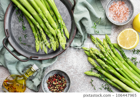 Bunch of raw asparagus stems with different spices 106447965