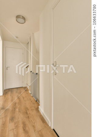 an empty room with white walls and wood flooring the door is open to let in light into the room 106633780