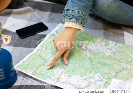 Close up picture of a female hand poing to the map 106747534