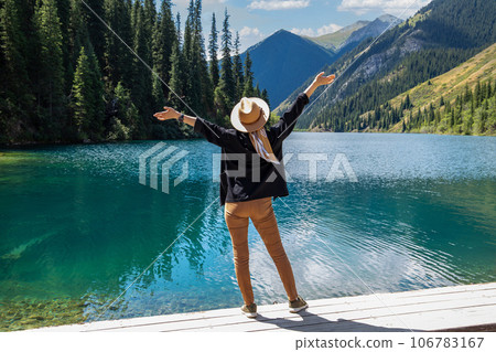 A woman tourist delighted with Kolsay lake in Kolsai Koldery gorge, nature of Kazakhstan National Park 106783167