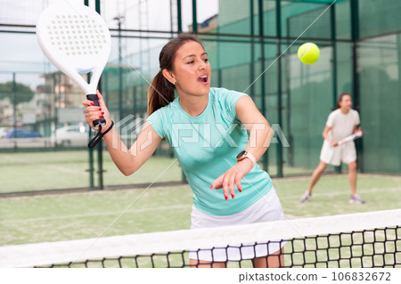 Young emotional women playing paddle tennis outdoors 106832672