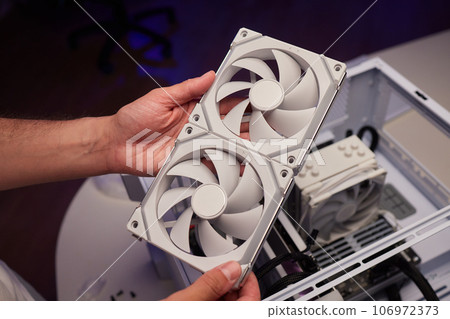 Computer technician installs cooling system of computer. 106972373