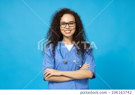 An attractive young girl in glasses and a blue nurse's uniform on a blue background 106163742