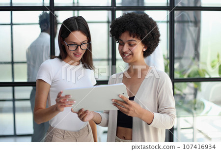 Two women analyzing documents office. Woman executives at work in office discussing some paperwork. 107416934