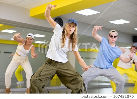 Teenage girl in cap training breakdance Toprock moves in dance hall 107421870