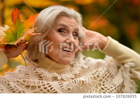 Senior woman walking in the park in autumn.  107826055