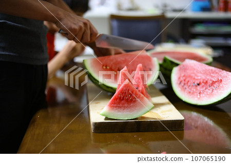 man cutting watermelon 107065190