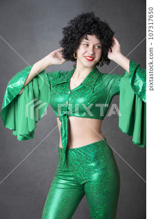 Beautiful vintage woman in an afro wig on a gray background. Disco girl. 107317650