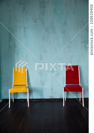 Yellow and red chair in the interior of an empty blue room 108639408