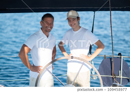 Dad showing his son how to manage the boat 109458977