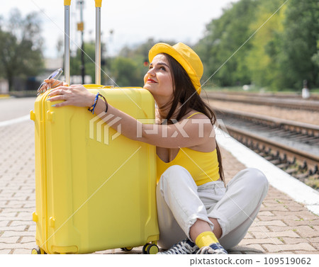 Forgetting about everyday life: a female image in sunny tones implies a vacation. A dreamy woman imagines her adventures in anticipation of new impressions and rest. Girl with suitcase 109519062