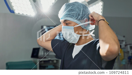 Surgery, doctor and man with face mask in hospital theatre for medical service, preparation and operation. Healthcare, safety scrubs and person with uniform for emergency, procedure and protection 109724811