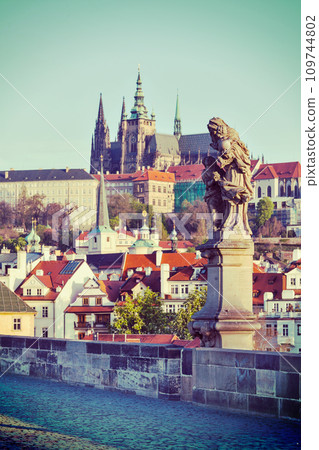 Statue on Charles Brigde against St. Vitus Cathedral in Prague 109744802