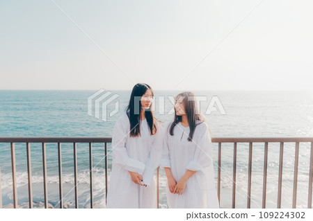 Two young women looking at the sea 109224302