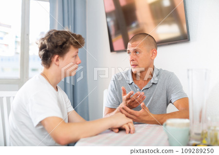 Portrait of guy with his father who are resting together at home 109289250