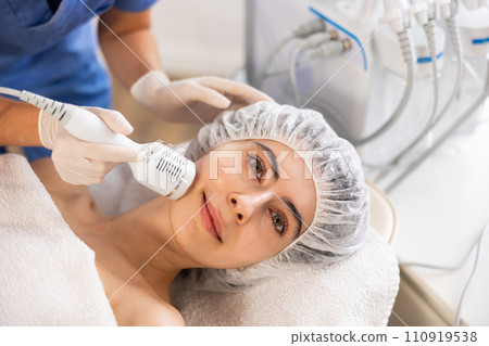 Female patient receiving hardware facial procedure using cooling attachment 110919538