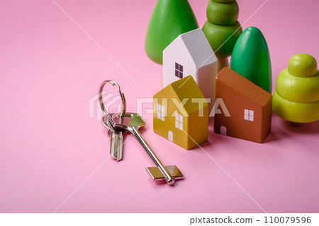 A small wooden house and keys as an idea for investing in your own home and achieving the goal of buying real estate 110079596