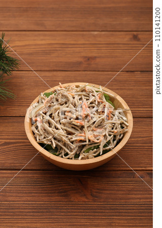 Burdock salad on a wooden plate 110141200