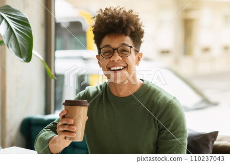 Portrait of happy young black guy enjoying coffee 110237043