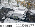 Two cars parked next to each other covered in snow. 111549177