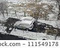 Two cars parked on street covered in snow. 111549178