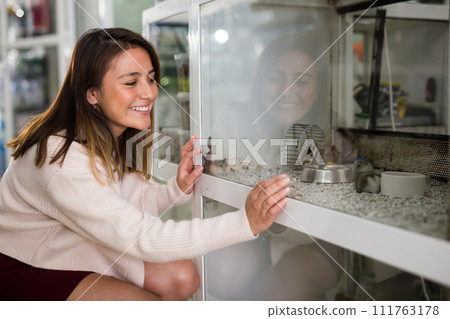 Woman visiting pet store in search of hamster 111763178