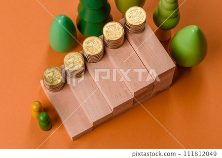 Conceptual composition of wooden steps with coins, model of a house 111812049