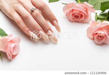 Female Hands on a white background with beautiful pearl manicure.Hands on a brown background and beautiful pearl manicure 111126906