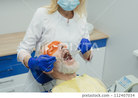 Male smiling during her dental treatment at dentist. 112407034