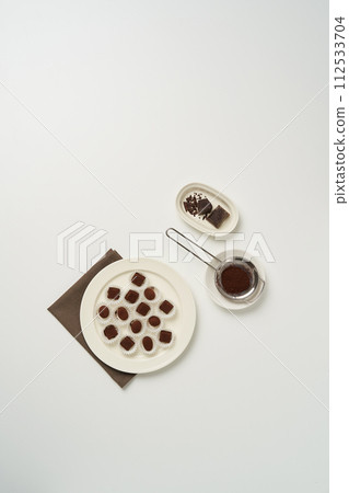 Handmade chocolate is served in several parchment cups 112533704