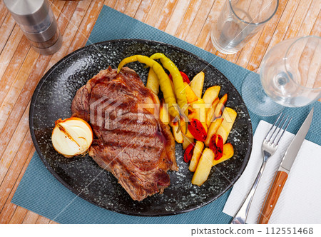 Beef entrecote with fried potatoes, peppers, tomatoes, onion 112551468