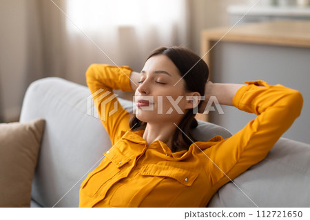 Woman relaxing with eyes closed on comfortable sofa 112721650