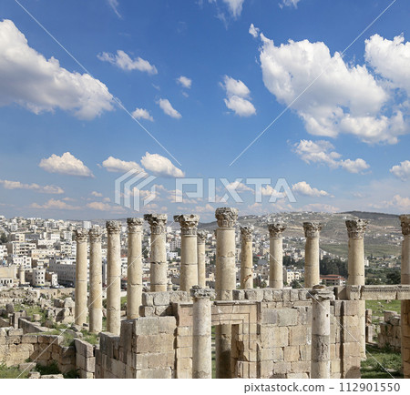 Roman ruins (against the background of a beautiful sky with clouds) in the Jordanian city of Jerash (Gerasa of Antiquity), capital and largest city of Jerash Governorate, Jordan 112901550