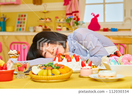 A young woman surrounded by sweets 112030334