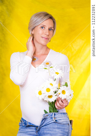 pregnant girl on yellow background with camomile 112232891