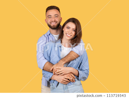 Embracing couple smiling on vibrant backdrop 113719343