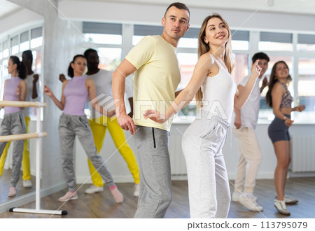 Young woman dances incendiary boogie woogie with man partner during choreography lesson 113795079