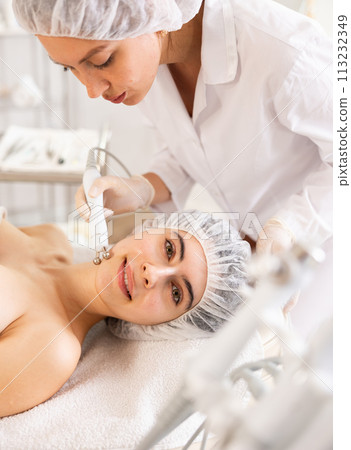 Young woman undergoing radiofrequency facial skin tightening procedure 113232349