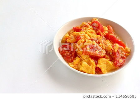 Fried eggs with tomatoes on white background 114656595