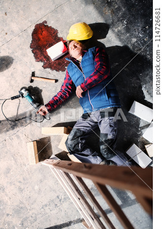 An unconscious man worker lying on the floor after a head injury. Work injury, accident in workplace. 114726681