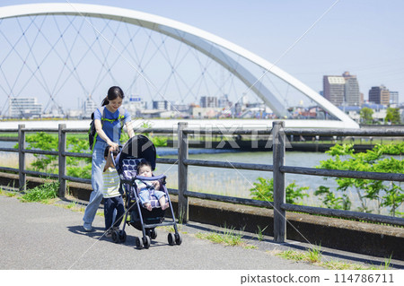 家長和孩子推著嬰兒車沿著河岸行走 114786711