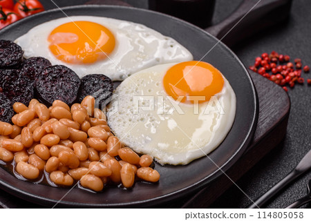 English breakfast with fried eggs, bacon, beans, tomatoes, spices and herbs 114805058