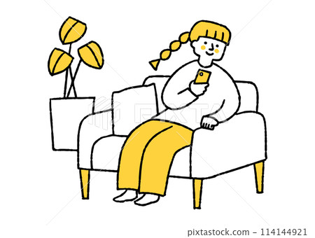 A woman sitting on a sofa and looking at her smartphone 114144921